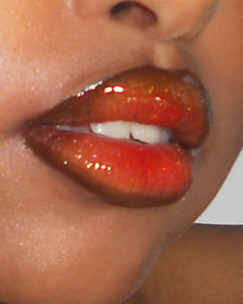 Close up of an orangetinted glossy fantasy lip combo.